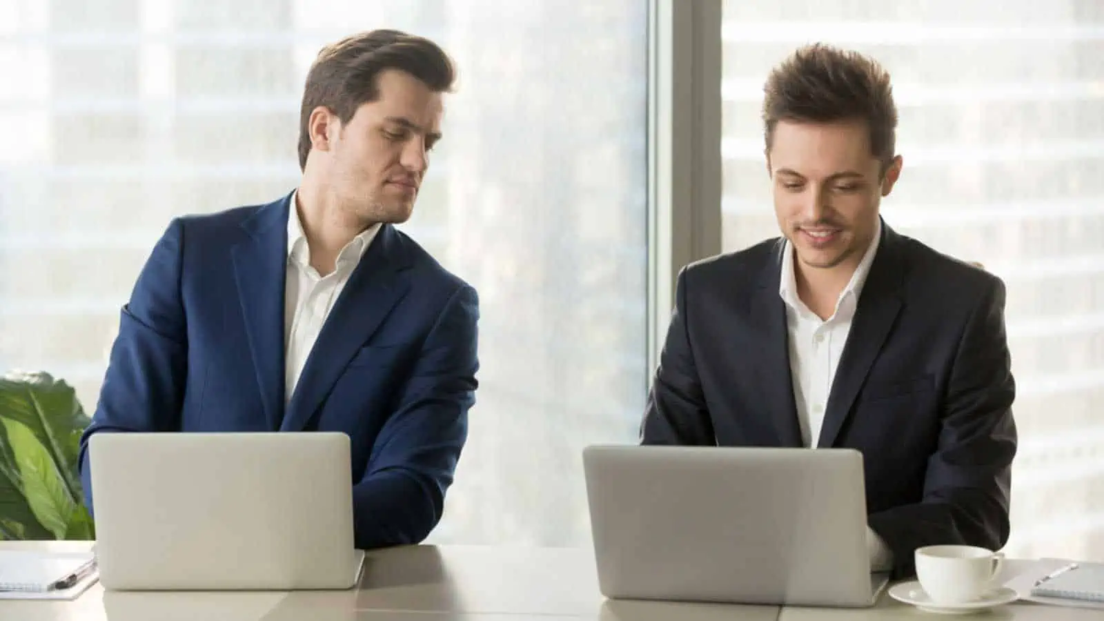 Manager peeping into employee laptop