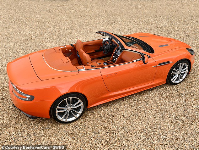 The paint and interior of the eight-car collection has been described as being the 'most striking hue of tangerine orange'. Pictured: 2011 Aston Martin DBS Volante