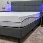 The Original Purple mattress in a bedroom next to two nightstands and bed lamps.