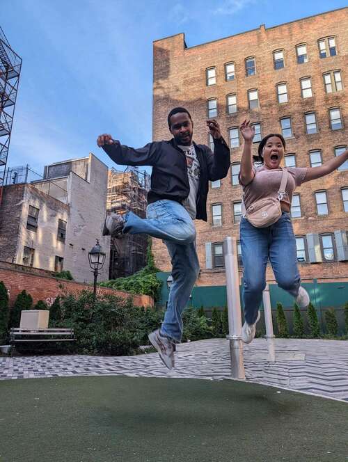 Two people jumping off a rock with the rock erased