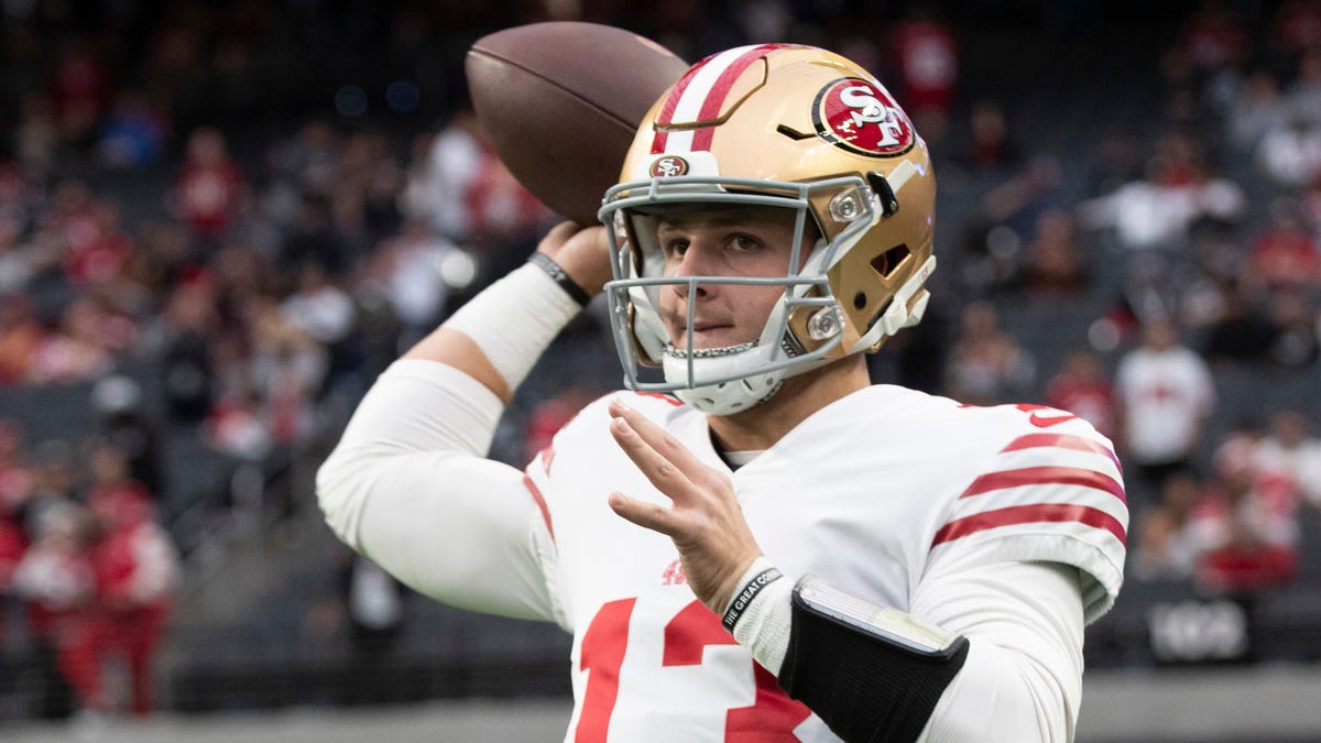 Quarterback Brock Purdy of the 49ers prepares to throw a football.