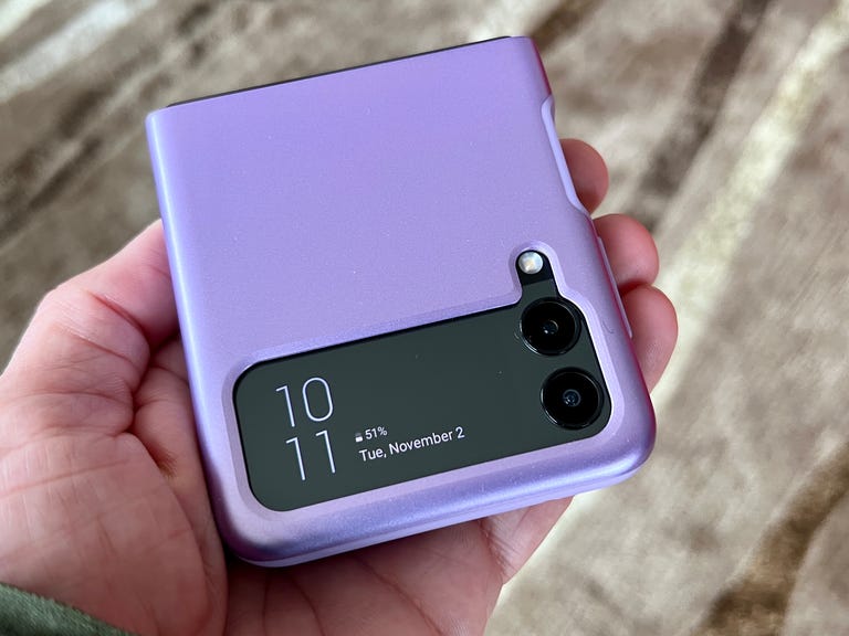 A hand holds a phone in a purple Spigen Thin Fit Galaxy Z Flip 3 case.