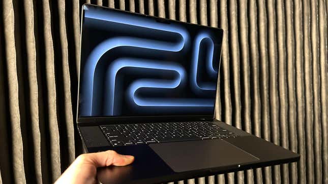 An M3-powered MacBook Pro with the Space Black color on a black corrugated background.