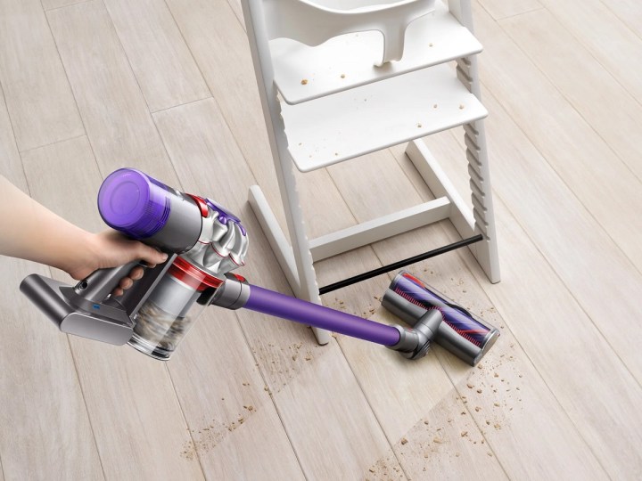 Someone using the Dyson V8 Origin Plus cordless vacuum.