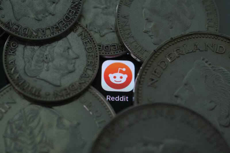 Reddit logo amidst darkened coins