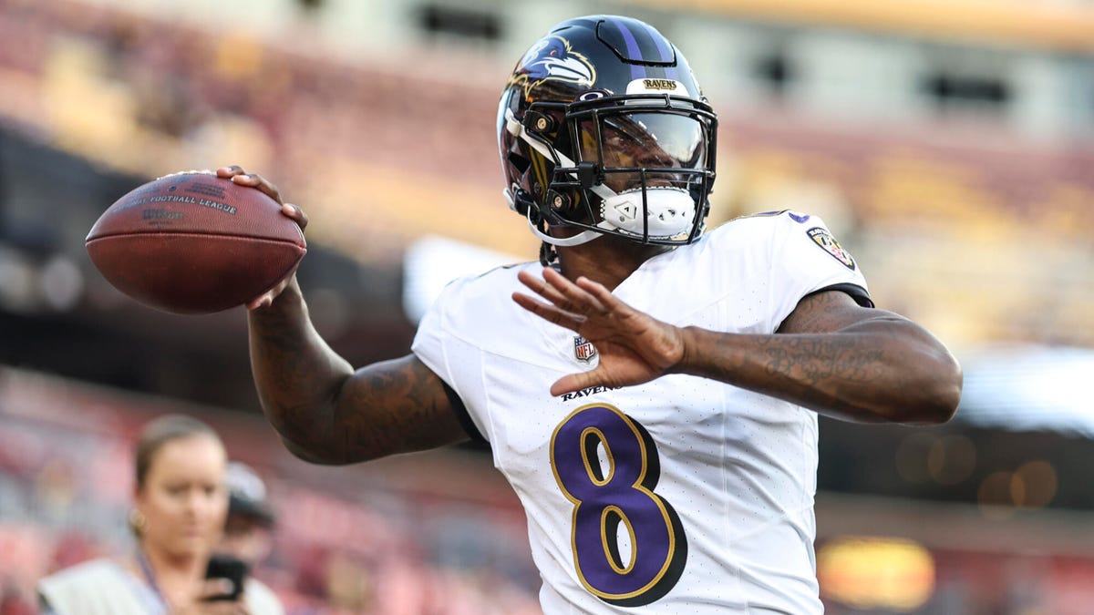 Baltimore Ravens quarterback Lamar Jackson preparing to throw a ball with his right arm stretched back.