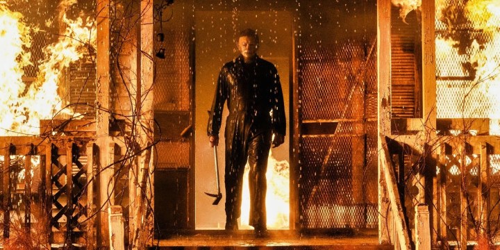 Michael Myers stands in front of a burning house in Halloween Kills