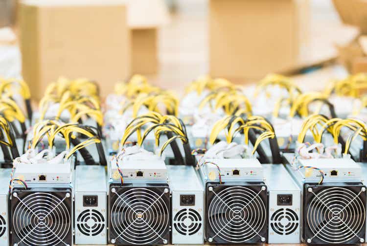 Rows of dedicated ASIC for cryptocurrency mining farm. Bitcoin, Ethereum and other altcoins producing rig.