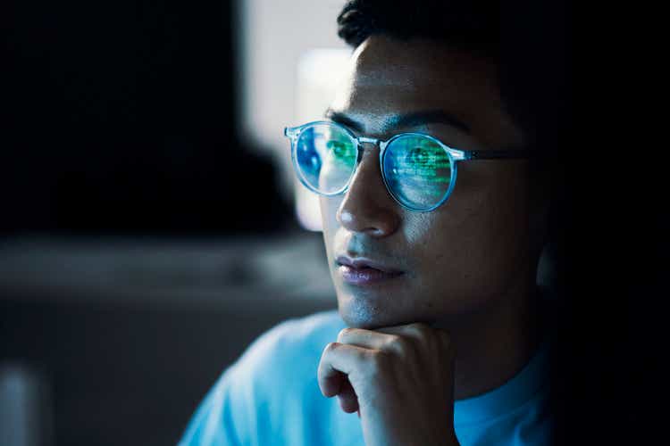 Code, Asian man and reflection in glasses, focus and programming for cyber security, hacking and modern office. Japan, male employee with eyewear and IT specialist coding, programming and thinking