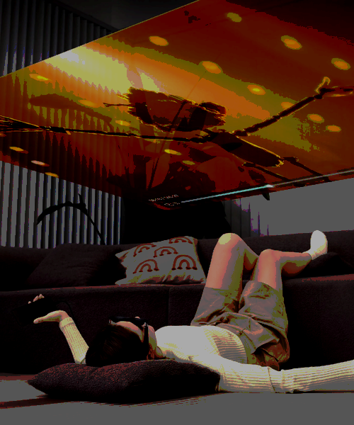 Person laying on floor watching screen displayed onto ceiling using AR glasses