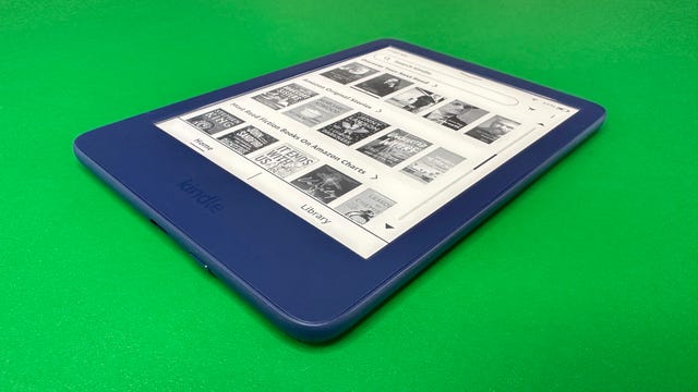 A side view of the Kindle 2022 in dark blue, against a green background