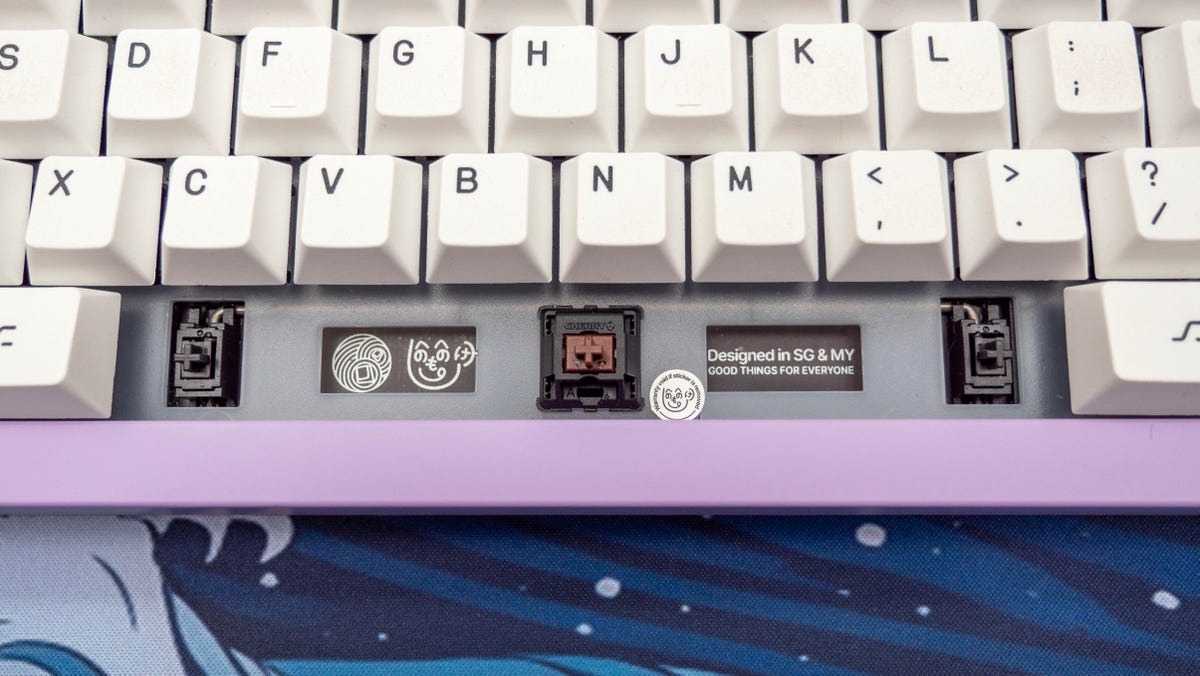 Monokei Standard mechanical keyboard with its spacebar keycap removed showing a Cherry Brown keyswitch and Cherry PCB stabilizer.