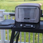 ninja outdoor oven on a table with a golf course behind it