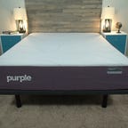 The Purple Restore mattress with a wooden bed frame against the back wall.