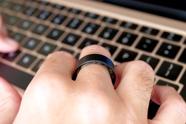 A person wearing the Ultrahuman Air ring, and typing.