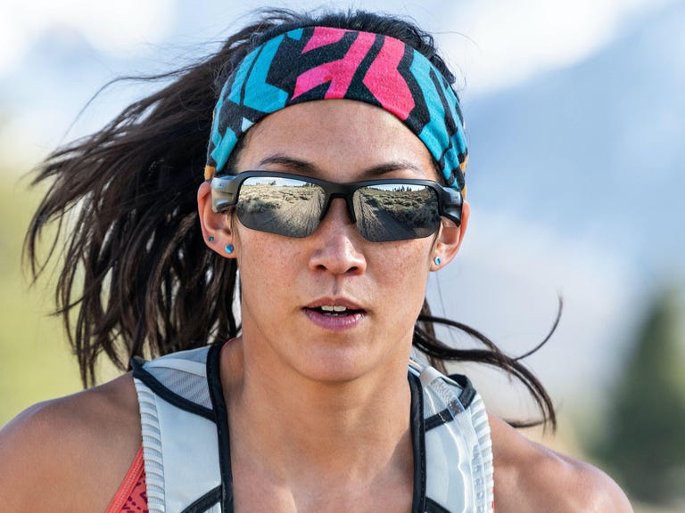 A woman running while wearing a pair of Bose Frames Tempo