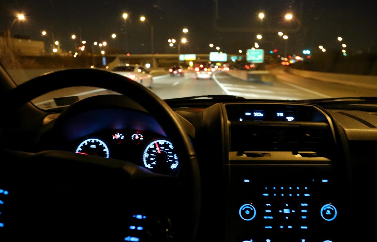 A lit-up car dash on a highway at night