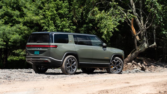 The all-electric 2022 Rivian R1S SUV looking cool in a light green and bright sunshine.