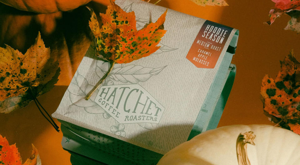 A soft pack of coffee from Hatchet Coffee Roasters surrounded by fall leaves and pumpkins.