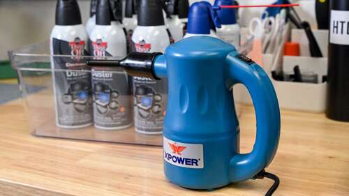 The XPOWER Electric Air Duster in front of compressed air cans