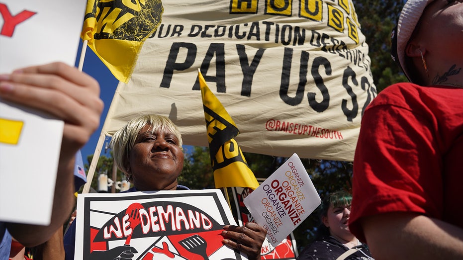 Workers hold signs