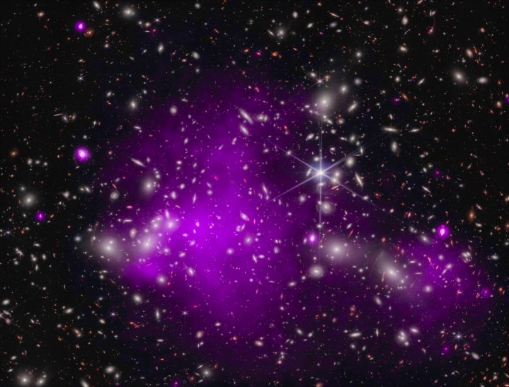 Astronomers found the most distant black hole ever detected in X-rays (in a galaxy dubbed UHZ1) using the Chandra and Webb telescopes. X-ray emission is a telltale signature of a growing supermassive black hole. This result may explain how some of the first supermassive black holes in the universe formed. This composite image shows the galaxy cluster Abell 2744 that UHZ1 is located behind, in X-rays from Chandra (purple) and infrared data from Webb (red, green, blue). 