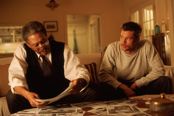 Morgan Freeman and Brad Pitt sit on a couch together in Seven.