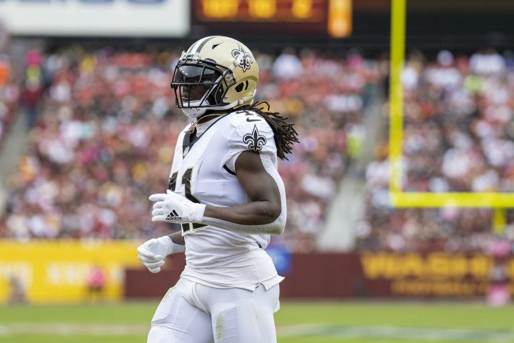 Alvin Kamara jogs on a football field.