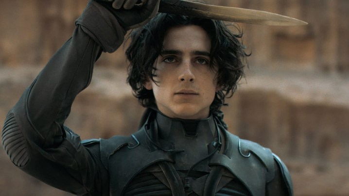 Timothée Chalamet as Paul Atreides saluting with his knife in Dune.