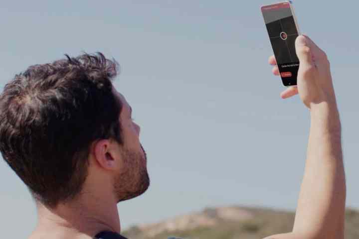 Man holding smartphone up to the sky to get a satellite fix.