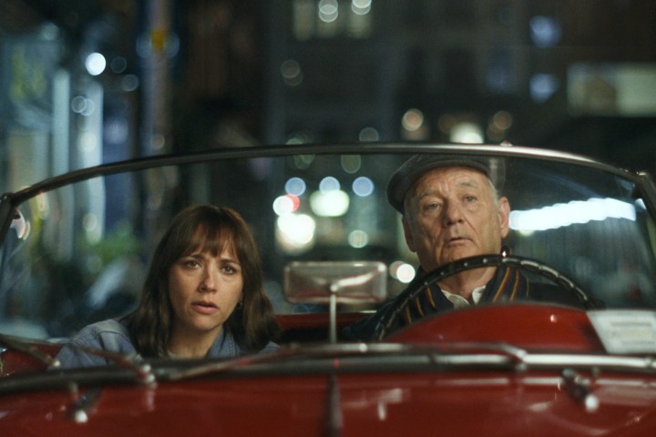 Rashida Jones and Bill Murray sit in a red car together in On the Rocks.