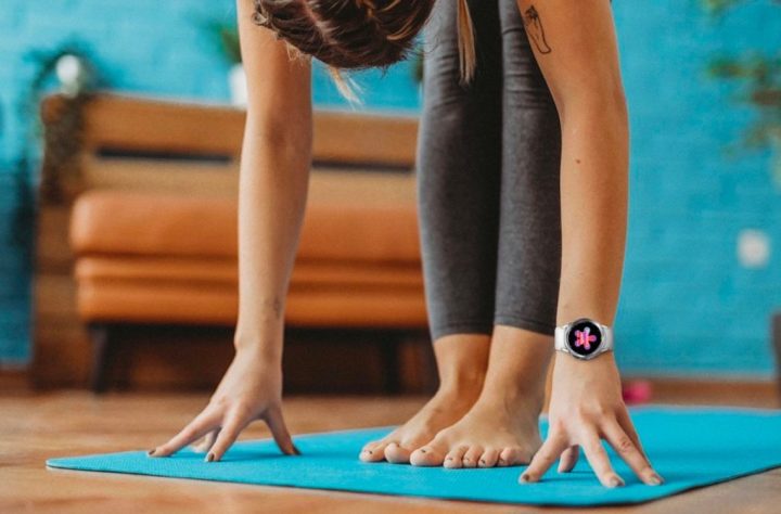 A woman does yoga while wearing a Samsung Galaxy Watch 4.