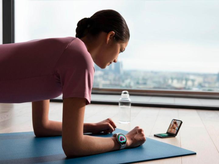 A woman does plank exercises while wearing a Samsung Galaxy Watch 6.