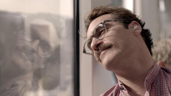 Joaquin Phoenix as Theodore leaning his head against a window in Her (2013).