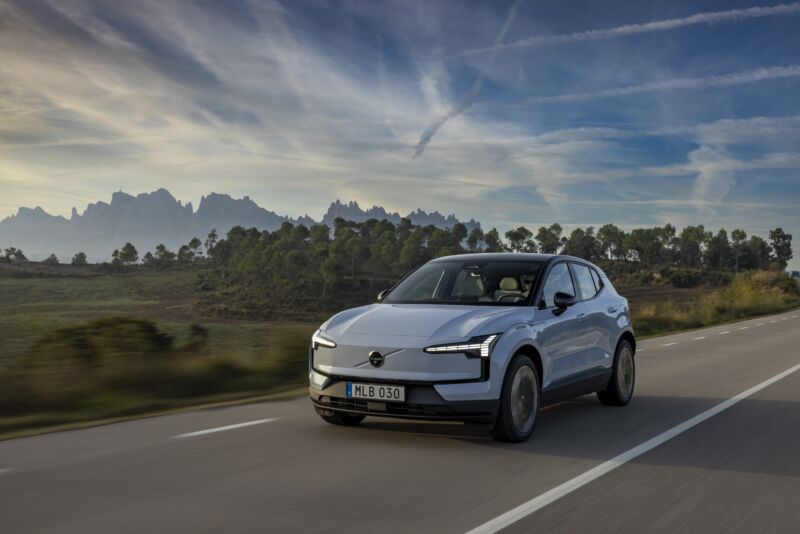 A blue-grey Volvo EX30 drives towards the camera