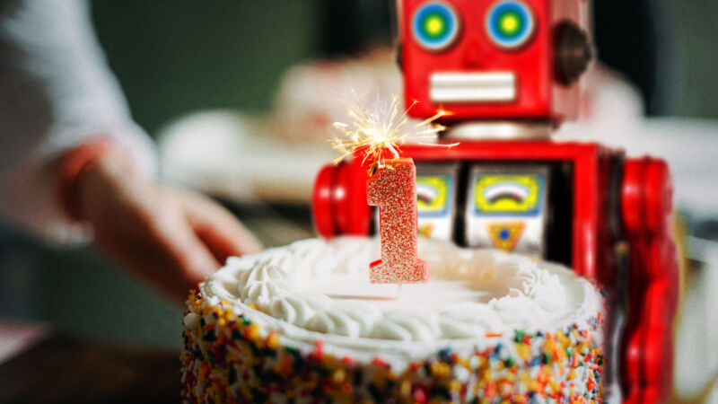 A toy tin robot blowing out a birthday candle.