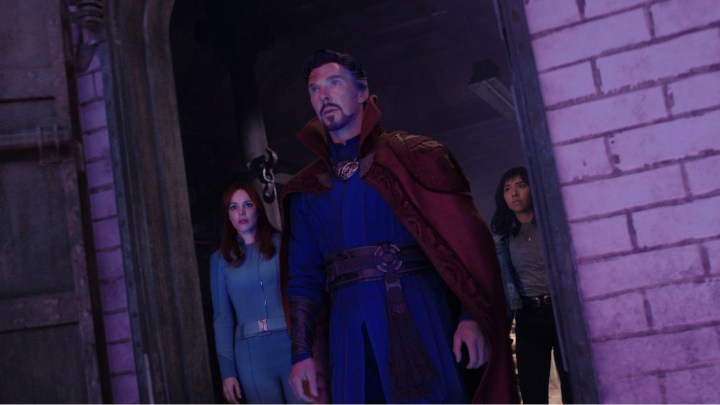 Rachel McAdams, Benedict Cumberbatch, and Xochitl Gomez look out a doorway i a scene from Doctor Strange in the Multiverse of Madness.