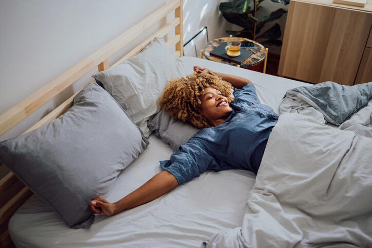 Woman stretching out in bed after waking up