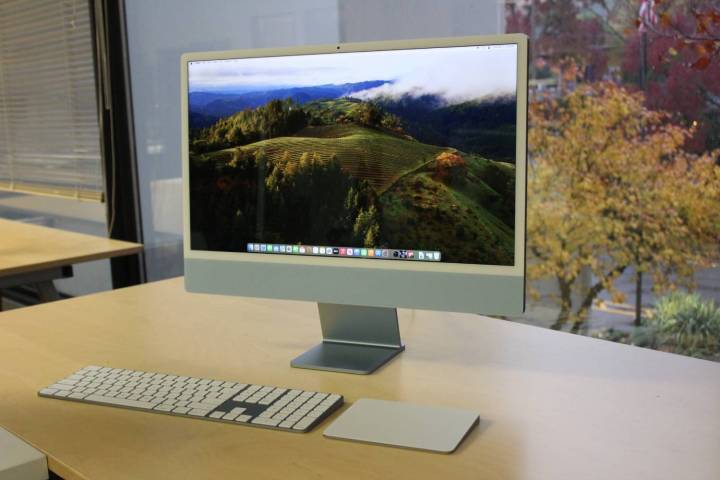 The display of the iMac in front of a window.