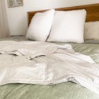 a white weighted blanket draped over a bed