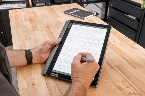 A person taking notes on the Lenovo ThinkBook Plus Gen 4's e-ink display