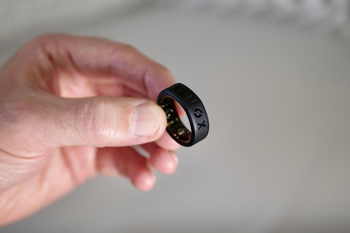 A person holding the Oura Ring in the Equinox Ring Cover.