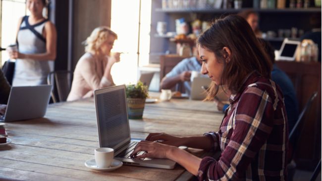 Person using a laptop computer at a coffee shop