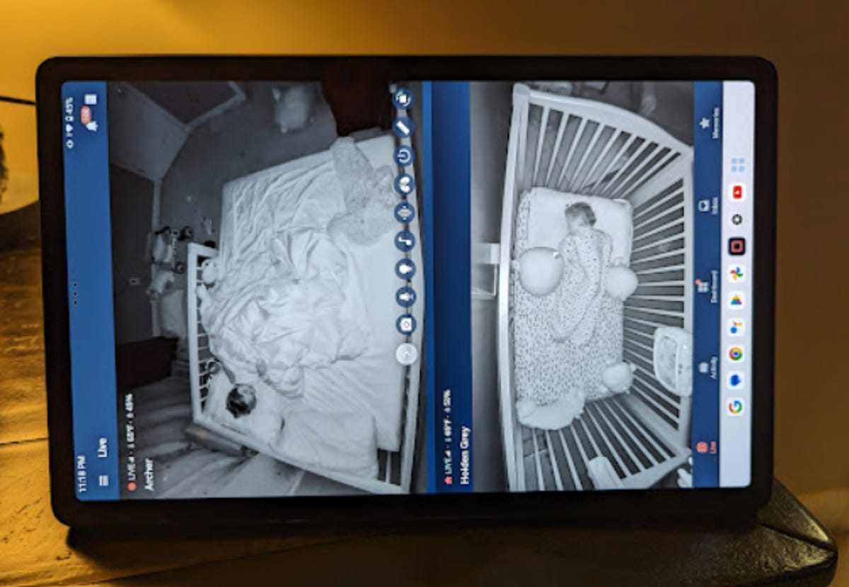 Tablet with a split screen showing two young boys asleep on a baby monitor