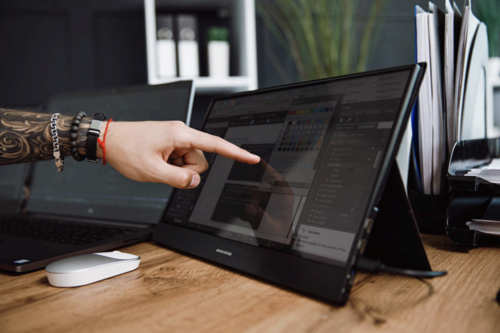 A user with the Desklab Portable 4K Touchscreen Monitor.