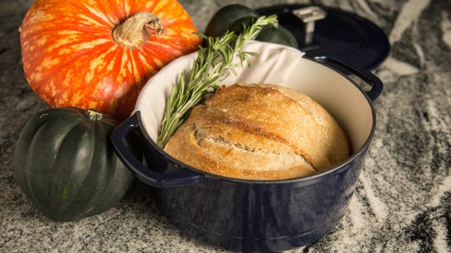 navy dutch oven with sourdough bread on table