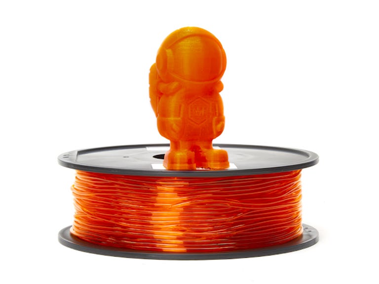 Orange roll of filament with an astronaut model on top