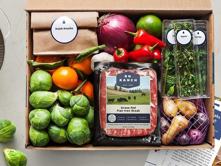 box of food items from blue apron, including meat, veggies, potatoes and herbs