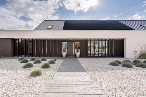 A house with solar panels in a desert setting.