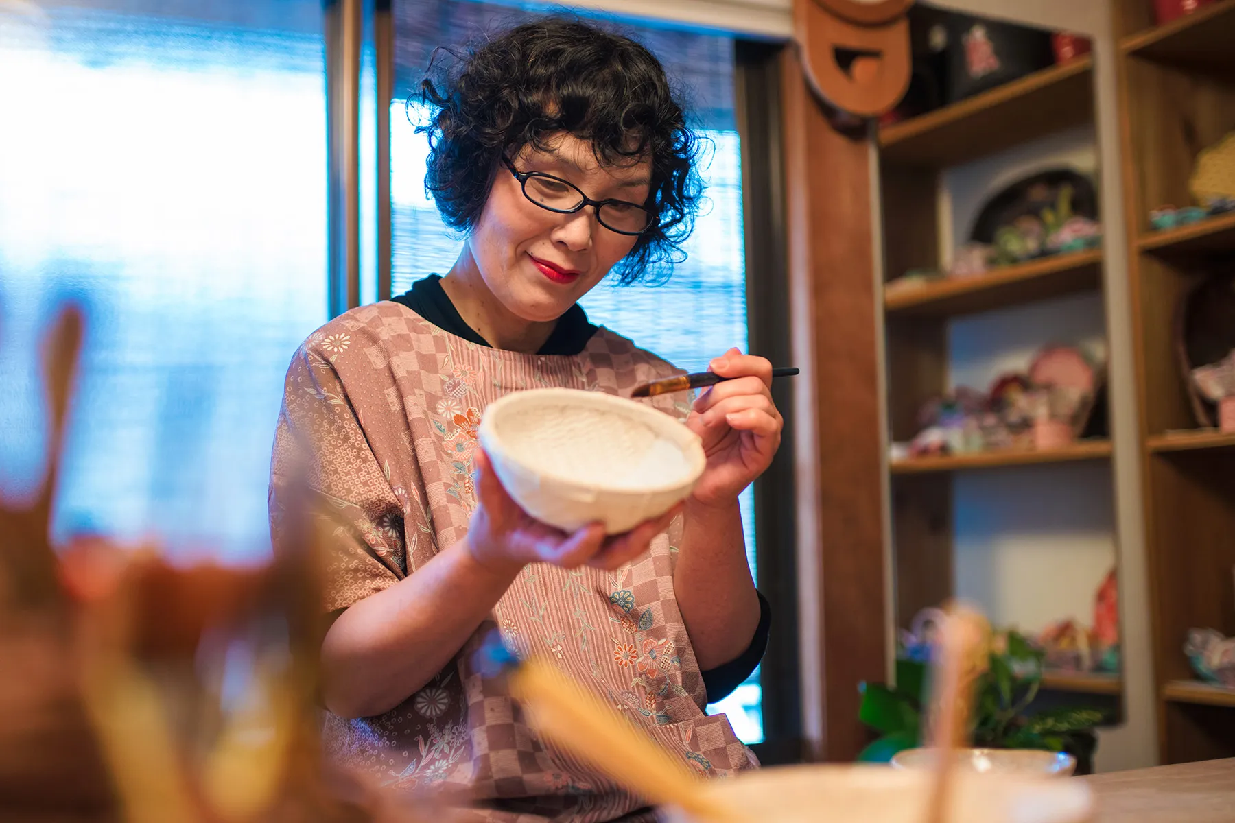 photo of woman painting pottery